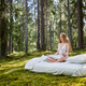Young woman is sitting in the forest on a white bed - PhotoDune Item for Sale