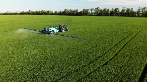 Aerial View of the Tractor That Irrigates the Green Field By Special Installation. The Process of