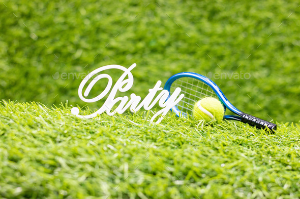 Tennis Party with ball and racket on green grass