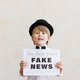 Newsboy shouting against grunge wall background. Boy selling fake news - PhotoDune Item for Sale
