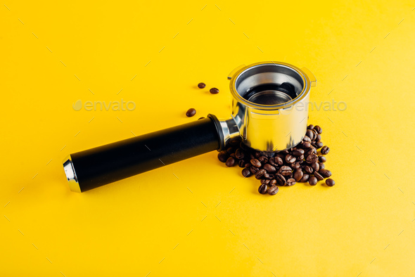 Portafilter on coffee beans. Yellow port background filter