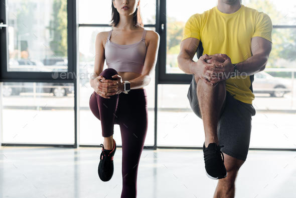 cropped view of sportsman and sportswoman working out together in sports center