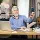 Mature man taking selfie with raised finger in home office - PhotoDune Item for Sale