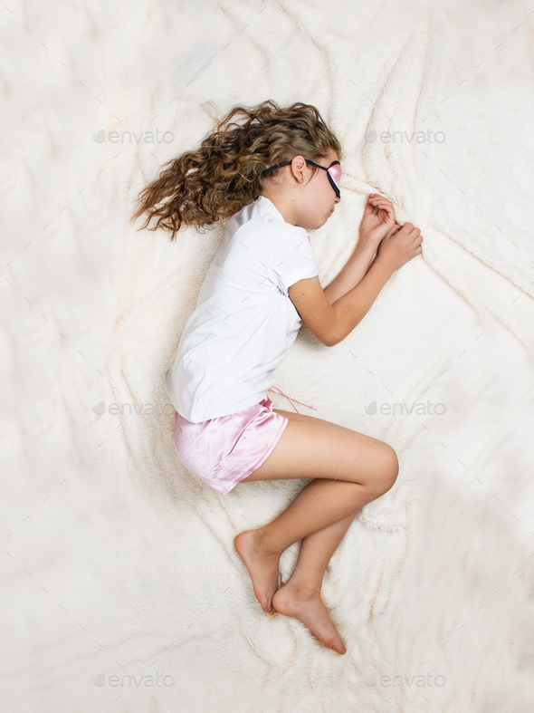 child sleeping in pajamas and sleep mask, top view,