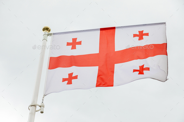 flag of Georgia with red crosses against sky