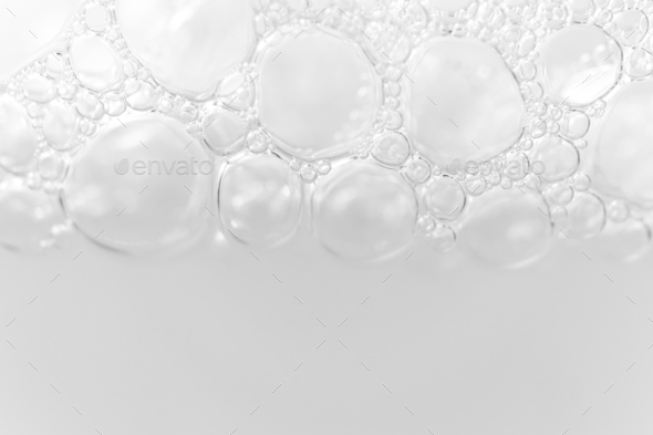 Border from foam bubbles from soap, shampoo or cleanser on white background. Macro