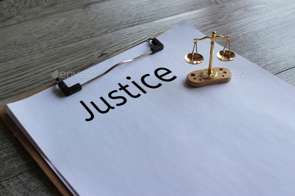 Close up image of balancing scale and text JUSTICE.
