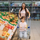 Family in the supermarket. young mother and her little daughter are smiling and buying food.  - PhotoDune Item for Sale