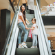 mother and little girl on the escalator in the mall.Mother and daughter in the mall.  - PhotoDune Item for Sale