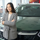 Beautiful brunette stands against the backdrop of sparkling new car - PhotoDune Item for Sale