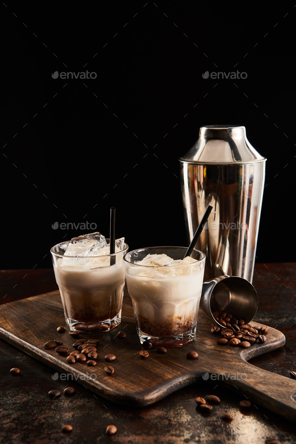 white russian cocktail in glasses with wooden board with coffee grains and shaker isolated Photo by LightFieldStudios