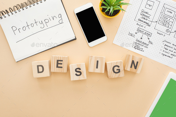 top view of gadgets near wooden blocks with design lettering, website design template, notebook with