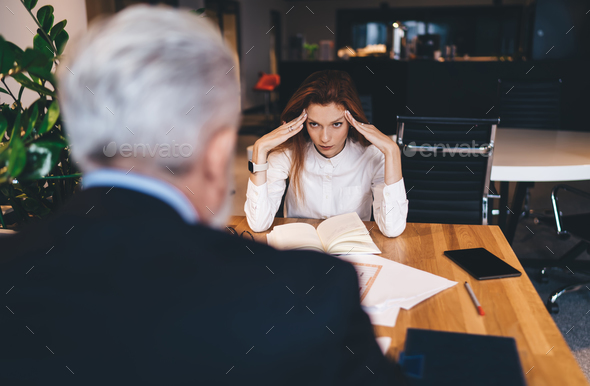 Annoyed businesswoman working in office with male colleague