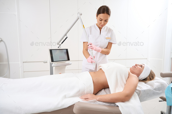 Woman in clinic on procedure laser peeling postpartum stretch marks