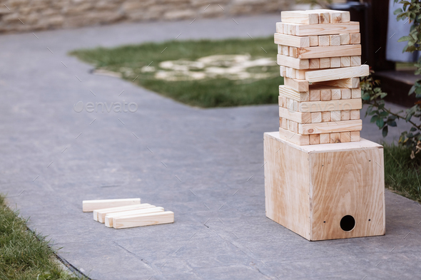 Jenga, multistory tower of wooden blocks. Group game of physical skill with big blocks for outdoor