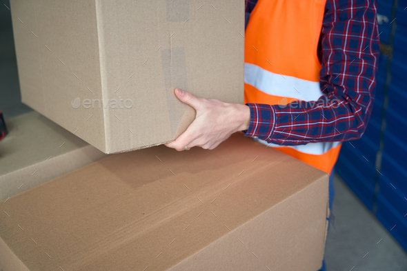 Close-up of large cardboard box in the mans hands of worker