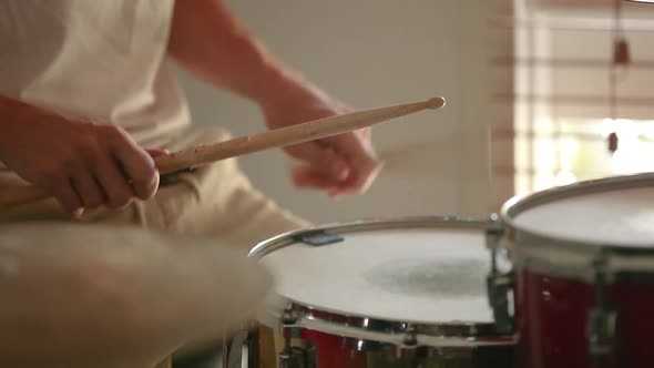 Drummer practicing medium speed parradiddle on snare drum. alt