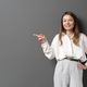 Happy young businesswoman posing over grey background - PhotoDune Item for Sale