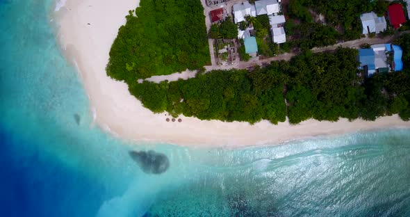 Tropical drone island view of a sandy white paradise beach and aqua blue water background in 4K alt