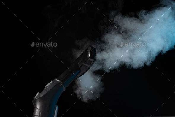 Steam cleaning with brush and steam on black background