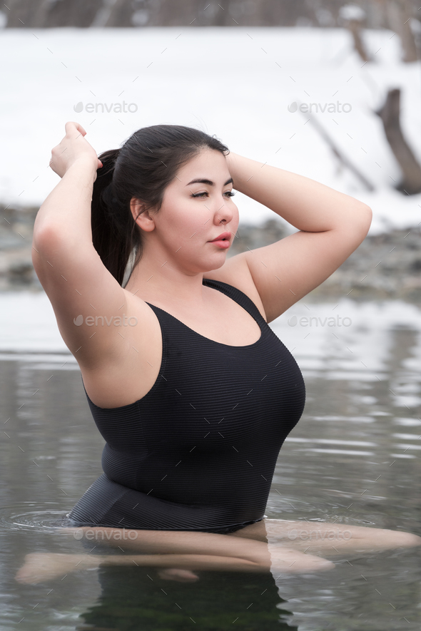 Large size young adult model with big breast in black swimsuit sitting in  outdoors pool spa resort Stock Photo by Kamchatka