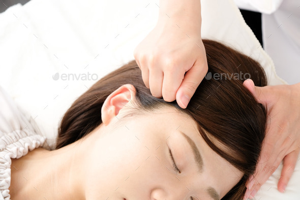 A woman receives pressure on her temples at an acupuncture clinic