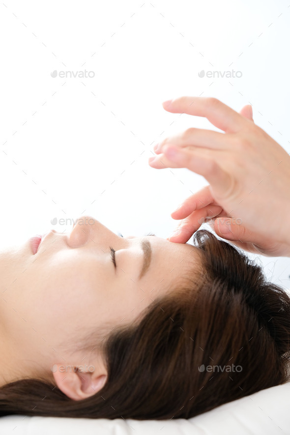Woman receiving acupressure between the eyes at an acupuncture clinic