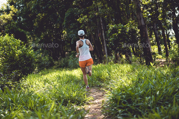 Woman trail runner running at tropical forest mountain peak - Stock Photo - Images
