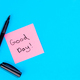 Pink note with inscription Good day and marker on blue background, flat lay. - PhotoDune Item for Sale