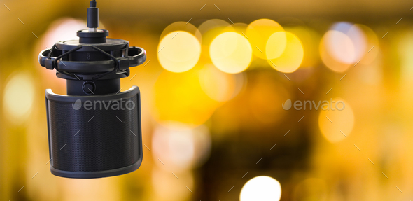 Professional condenser microphone for record voice on golden bokeh background. Professional mic
