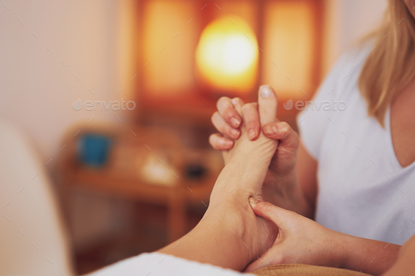 Woman having foot reflexology massage in salon - Stock Photo - Images