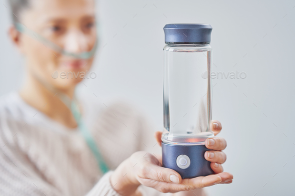 Picture of woman having hydrogen water in hand