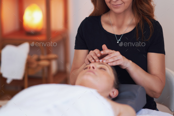 Woman having a face massage treatment in studio - Stock Photo - Images