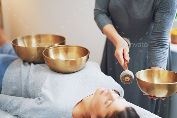 Woman having a Tibetan sound bowl massage - Stock Photo - Images