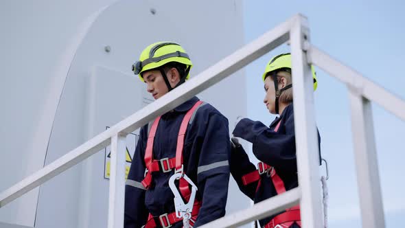 Two maintenance engineers in safety gear working at height inspect safety gear working at height