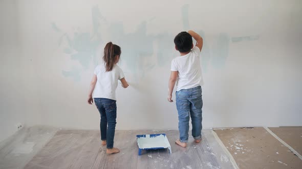 Caucasian Boy and Girl Paint the Wall with Brushes Brother and Sister Paint on the Wall Kids Get