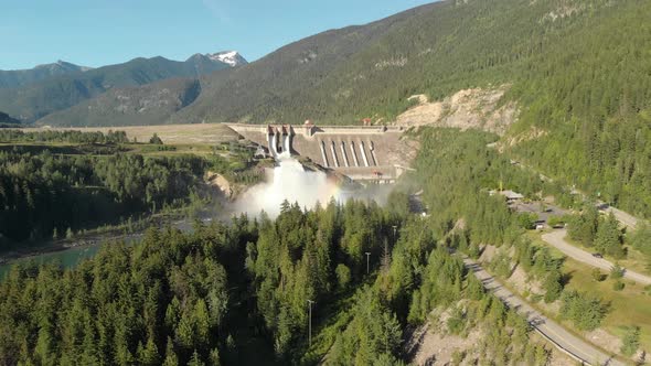 Aerial Shoot of Revelstoke Dam at noon, Surrounded by Mountrains and Pine Trees alt