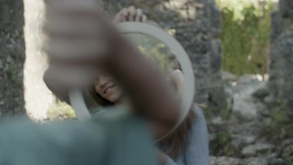 Reflection of Boy Making Spell Gestures with Hands in Mirror alt