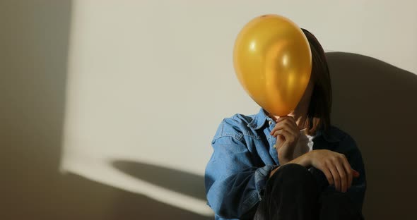 young beautiful woman having fun with golden balloons at home party. Throws up balloons. happy girl 