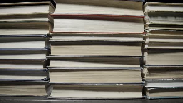 Stacks of Books are Lying on the Table in the Library alt