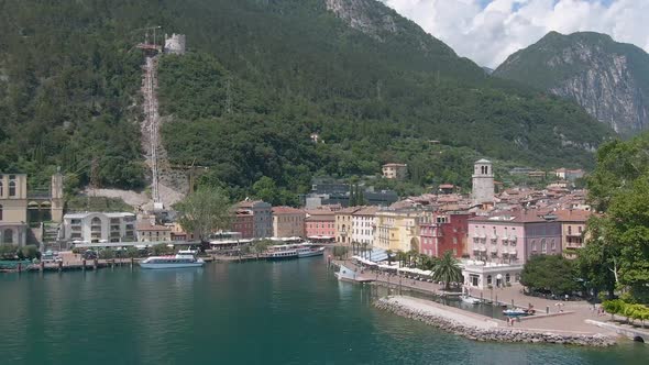 Drone flying towords the plaza in the center of the north italian city Riva Del Garda with the lake alt