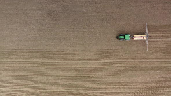 AERIAL - Tractor spreading fertilizer on field, agriculture, plan view wide shot alt