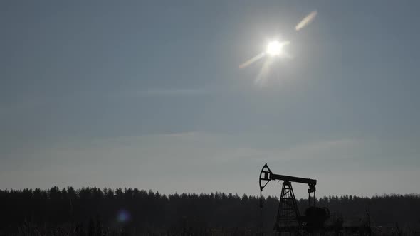 Silhouette of Old Nonworking Oil Pump From Oil Field at Sunset