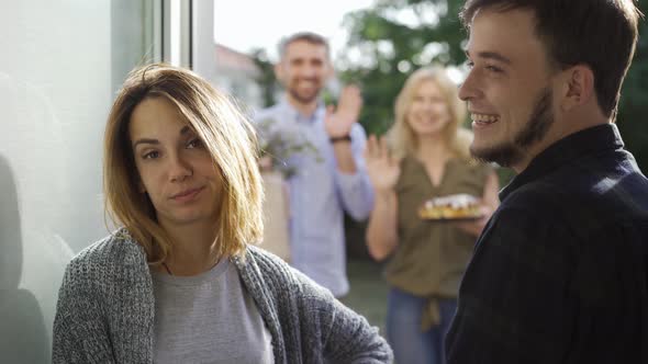 Young Married Couple Meeting Annoying Guests Standing at Doors alt
