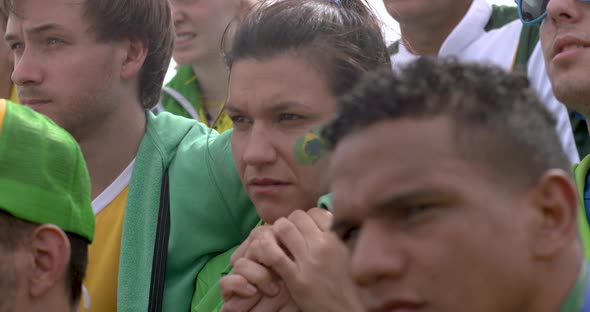 Brazilian football fans looking disappointed and frustrated at match, slow motion