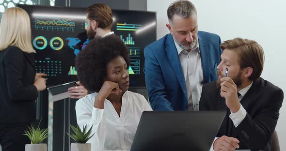 Businessman Talking with Blond Female Colleague while Anothers Members of their Team alt