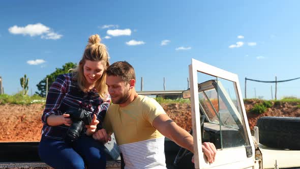 Couple looking at photos on digital camera 4k alt