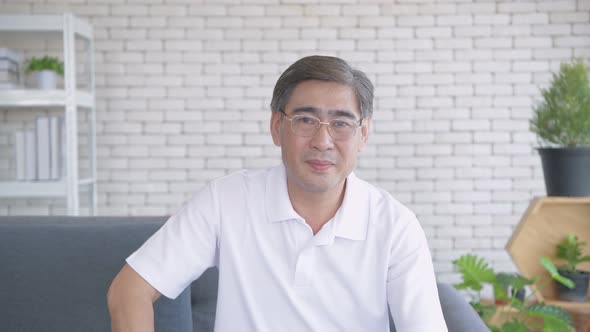 Family concept. An Asian old man greeting through the camera. 4k Resolution. alt