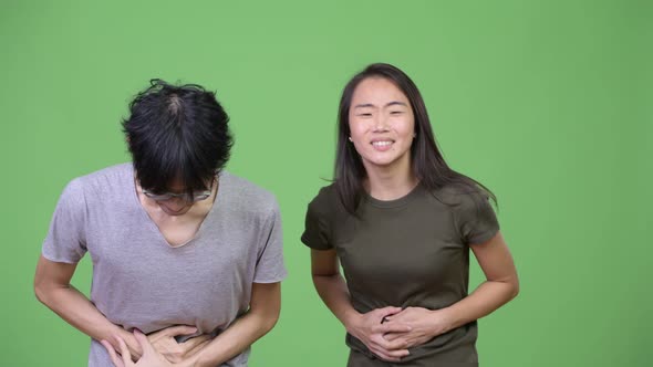 Young Asian Couple Having Stomach Ache Together