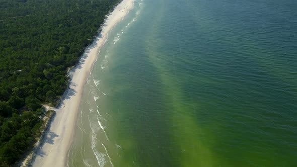 Tilt up from the turquoise tropical Osetnik beach waters with white sand to the sky, Poland alt